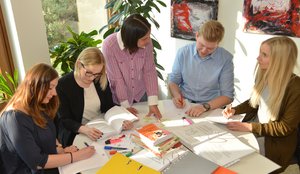 Mehrere Auszubildende und Studierende sitzen an einem Tisch zusammen und lernen. Foto: Judith Wedderwille/ Kreis Soest