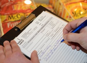 Klemmbrett mit Protokoll zur Lebensmittelkontrolle", rechte Hand füllt das Protokoll gerade aus. Foto: Judith Wedderwille/Kreis Soest