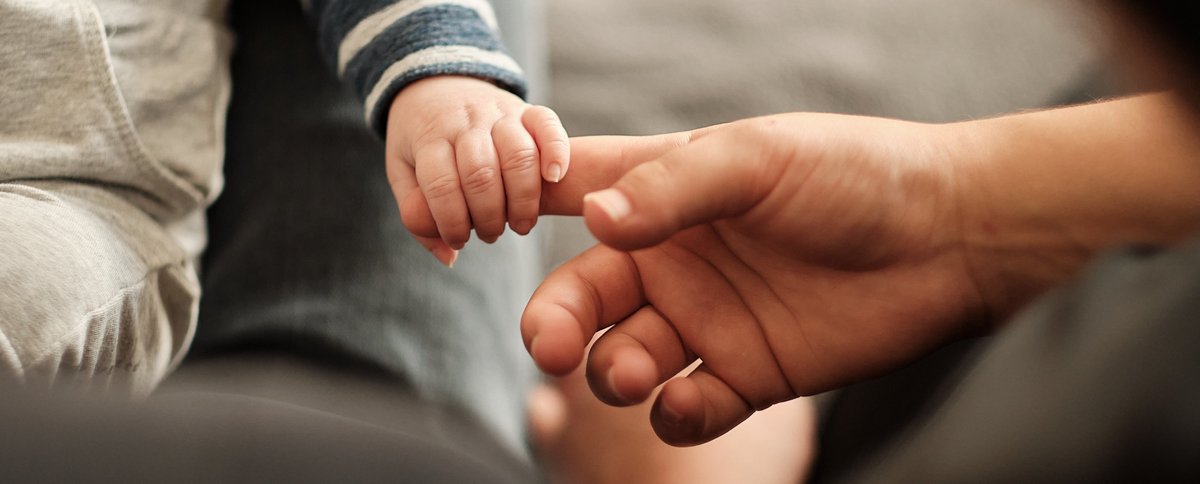 Babyhand hält den Finger einer Erwachsenenhand. Foto: karin.schlueter.de