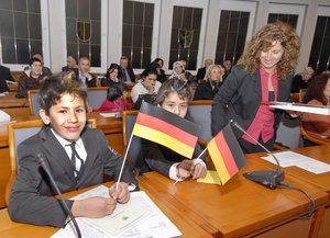 Zum ersten Mal veranstaltete der Kreis Soest am 1. Dezember 2009 eine Einbürgerungsfeier. Diese beiden jungen Neubürger zeigten sofort "Flagge", als sie die Urkunde erhalten hatten. Foto: Wilhelm Müschenborn/Kreis Soest
