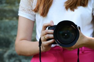 Eine Frau hält eine Kamera in der Hand.