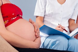 Hebamme untersucht Bauch einer Schwangeren. Foto: © Iurii Sokolov - Fotolia.com