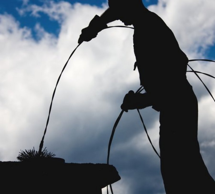 Schornsteinfeger vor Himmel mit Wolken bei der Arbeit. Foto: © krizz7 - Fotolia