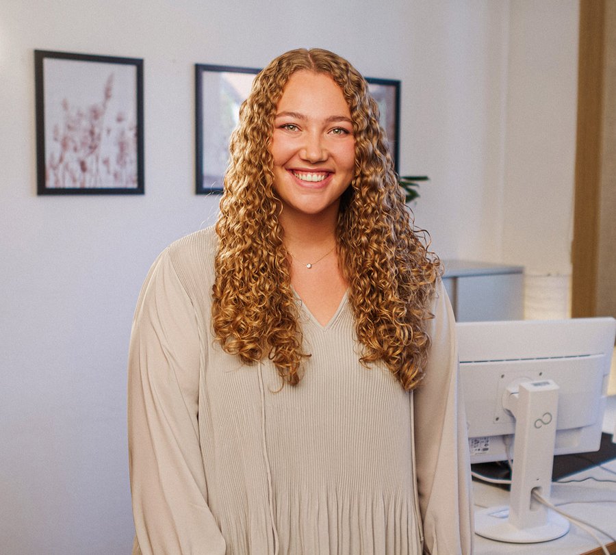 Traineeprogramm im Jugendamt. Foto: Thomas Grimm Eine Frau stet in einem Büro und lächelt in die Kamera. Foto: Thomas Grimm