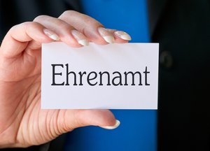 Frau hält Karte mit Beschriftung "Ehrenamt". Foto: © DOC RABE Media - Fotolia.com