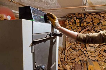 Holzheizung bedienen. Foto: © Jürgen Fälchle - Fotolia.com