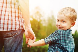 Erwachsener hält kleinen Jungen an der Hand. Foto: © solovyova - Fotolia.com