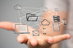 Symbolbild Digitalisierung: Über eine Hand schweben verschiedene miteinander vernetzte Grafiken wie ein Laptop, ein Server und ein Smartphone. Grafik: ©vege - stock.adobe.com