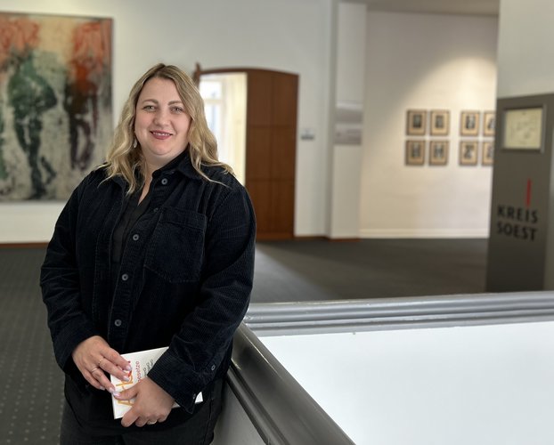 Eine Frau steht mit einem Gesetz im Bereich des Sitzungstraktes des Kreishauses.