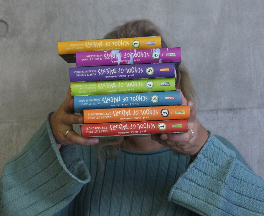 Die Kinderbuchautorin Silke Schellhammer, Patin des 21. Lesewettbewerbs auf Kreisebene, vor einem Stapel Bücher. Foto: Nele Schellhammer