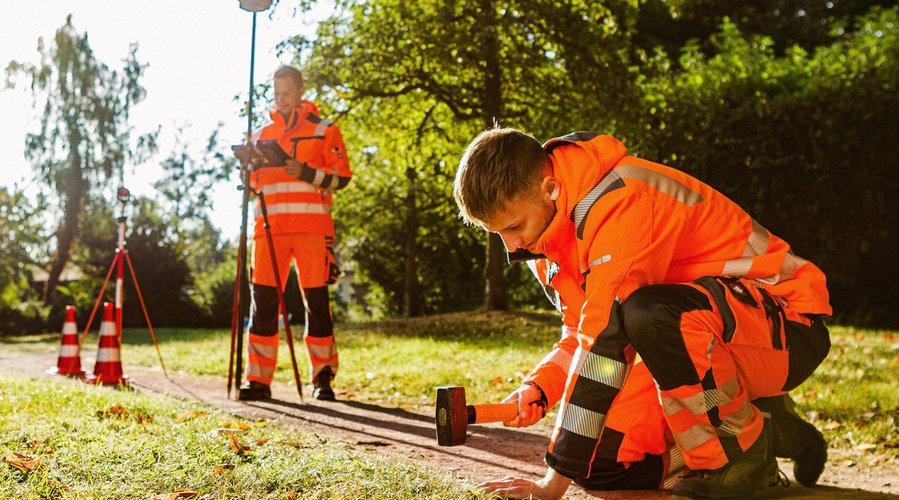 Vermessungstechniker. Foto: Thomas Grimm Ein Mann setzt einen Grenzstein. Ein anderer Mann dokumentiert dies technisch. Foto: Thomas Grimm