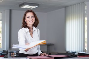 Büroangestellte überreicht Unterlagen. © Frank Merfort - Fotolia.com