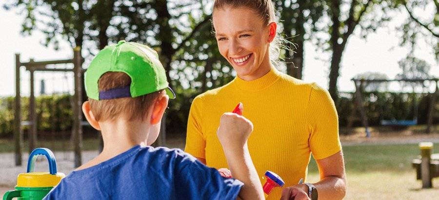 Eine Frau spielt mit einem Kind im Freien. Foto: Thomas Grimm