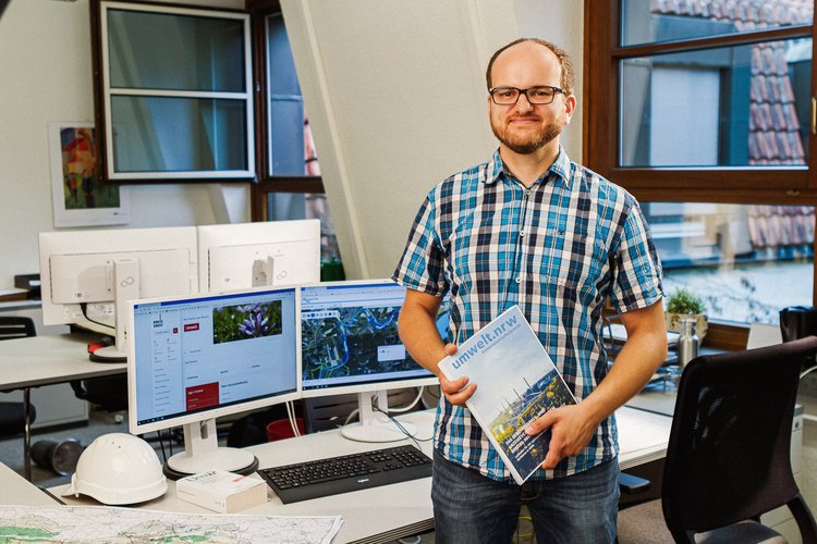 Ein Mann steht mit einer Umweltrechts-Sammlung im Büro. Foto: Thomas Grimm