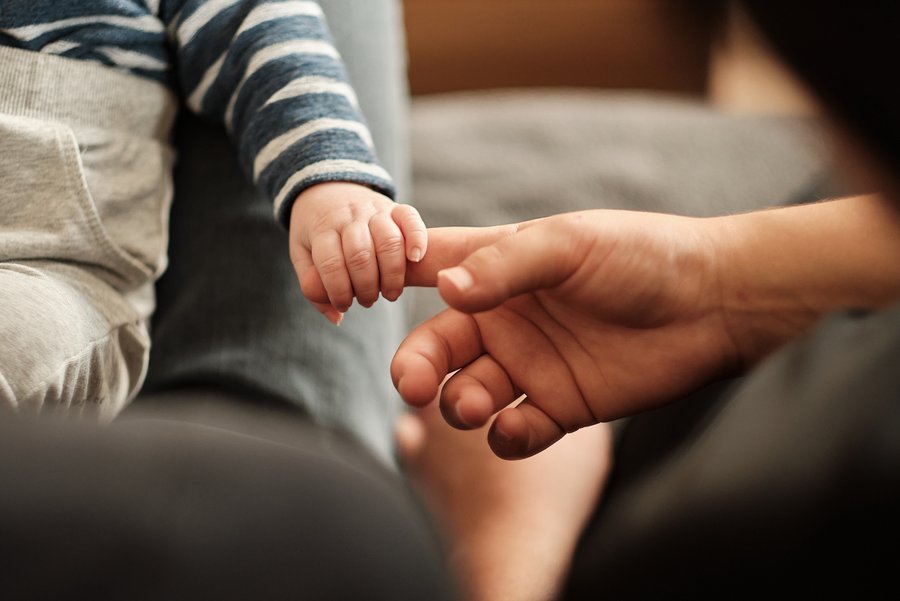 Babyhand hält den Finger einer Erwachsenenhand. Foto: karin.schlueter.de