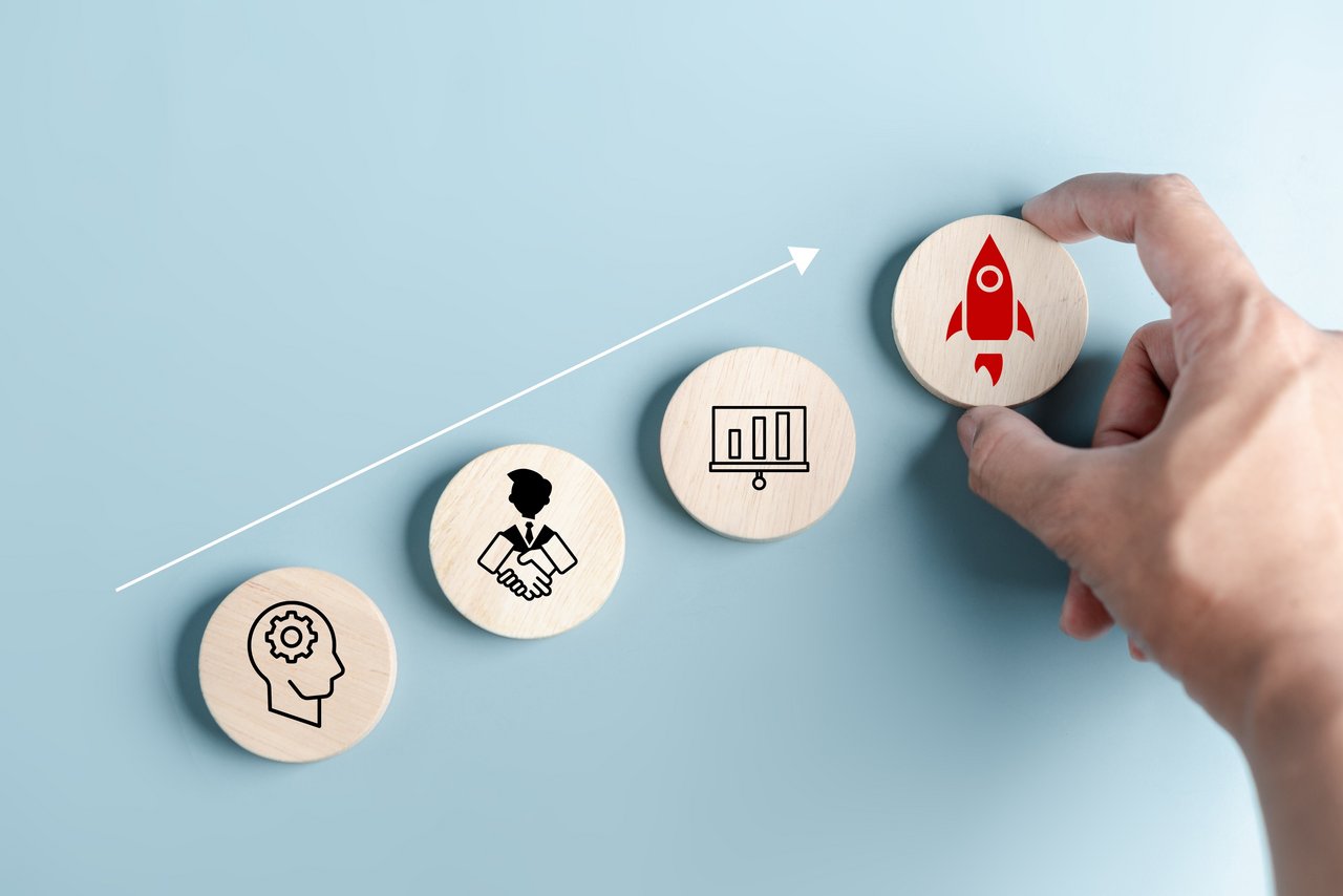 Holzsteine mit verschiedenen Pictogrammen, die für berufliches Vorwärtskommen stehen. Foto: Kiattisak/stock.adobe.com