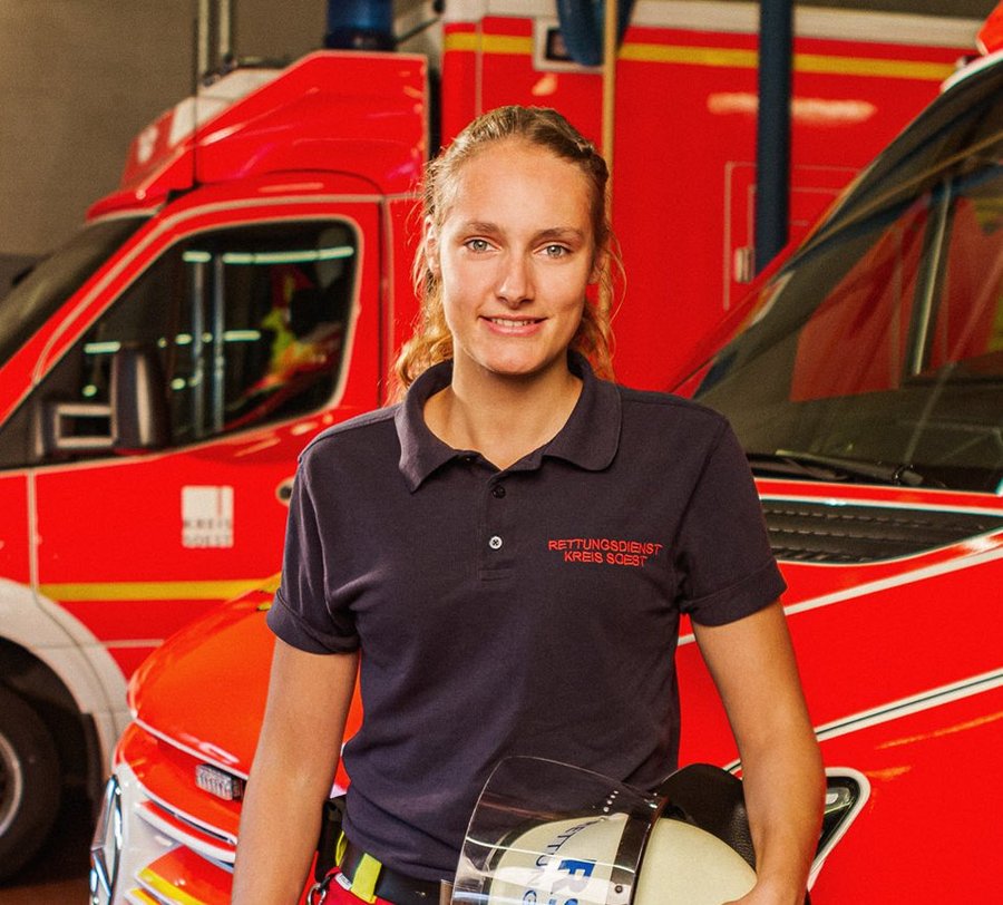 Eine junge Frau steht in Dienstkleidung vor einem Rettungswagen des Kreises Soest. Foto: Thomas Grimm