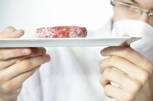 Mann kontrolliert Fleisch. Foto: © PHILETDOM - Fotolia.com