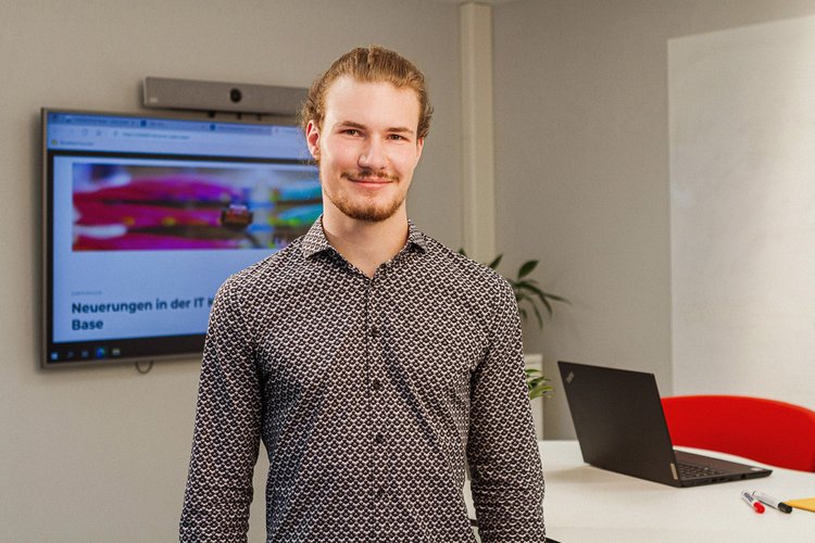 Bachelor of Science - Verwaltungsinformatik E-Government. Foto: Thomas Grimm Ein Mann steht vor einem modernen Schreibtisch mit Laptop, im Hintergrund ist ein großer Flachbildschirm und ein Whiteboard. Foto: Thomas Grimm