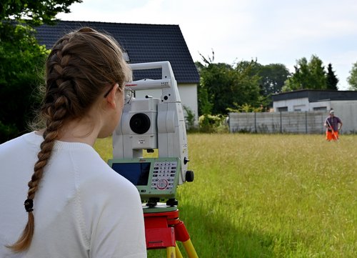 Auszubildende Johanna Grae überprüft den Standort ihres Kollegen mithilfe eines Messgerätes. Gemeinsam wollen sie die vier Eckpunkte einer geplanten Rettungswache abstecken. Foto: Kira Hönicke/ Kreis Soest
