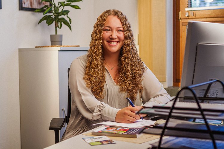 Traineeprogramm im Jugendamt. Foto: Thomas Grimm Eine Frau sitzt lächelnd an ihrem Arbeitsplatz. Foto: Thomas Grimm