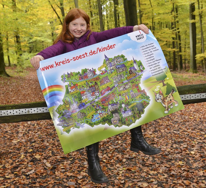 Plakat zur Kinderwebseite. Foto: Thomas Weinstock/ Kreis Soest Mädchen mit roten Haaren präsentiert das Plakat der Kinderwebseite Kreis Soest. Foto: Thomas Weinstock/ Kreis Soest