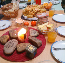Bei den Treffen machen es sich alle immer so gemütlich wie möglich. Oft gibt es ein bisschen was zu Essen und zu Trinken. Auf dem Tisch steht immer die Sommerlandkerze mit der Sonne, die halb dunkel und halb hell ist. Um die Kerze herum  liegen dann auch oft Steine mit Namen von Menschen darauf. Die Jungen und Mädchen in der Gruppe erinnern sich so an Freunde und Verwandte, die gestorben sind. Foto: Maria Düster/ Diakonie Ruhr-Hellweg
